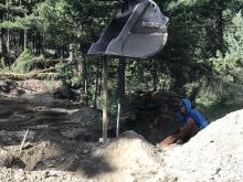 Excavator pounding post near hydrant